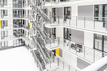 the courtyard of a multi-storey building. a multi-storey hotel , apartment or hostel. Everything is covered with snow. View of the large balconies and windows of the apartment building.