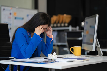 Tired asian businesswoman with headache at office, feeling sick at work.