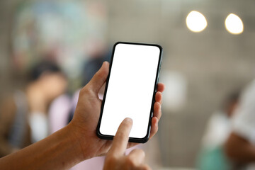 Mockup image of hand holding white mobile phone with blank white screen in cafe.