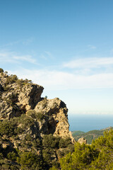 Vertical image of amazing elephant shaped rock mountain on a sunny day with a blue sky and the sea in the background