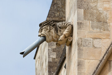 Closeup of humorous gargoyle at southern facade of Chichester Cathedral, West Sussex, UK