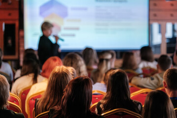 Group of people attentively listening to speaker during business presentation in conference...