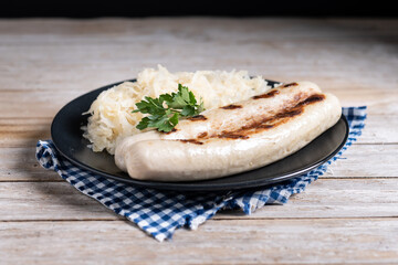 Bratwurst sausage and sauerkraut on wooden table