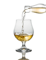 Brandy pouring into a glass on a white background.