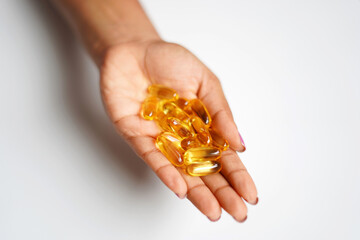 omega 3 capsules on hand image. closeup