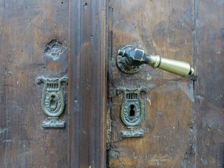 Old door handle and keyholes with decoration on the door