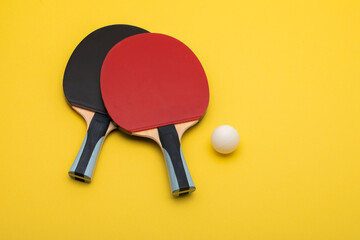 Professional Ping Pong Paddles with Ball on Vibrant Yellow Background