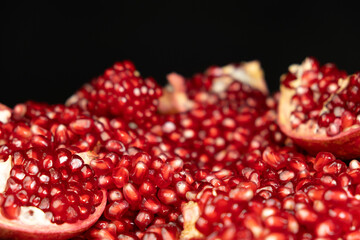 Pomegranate background, lots of peeled pomegranates and seeds, black background