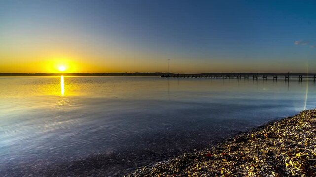 Starnberg Lake time lapse at sunset with calm water and colorful sky, peaceful nature landscape in Bavaria, Germany.
