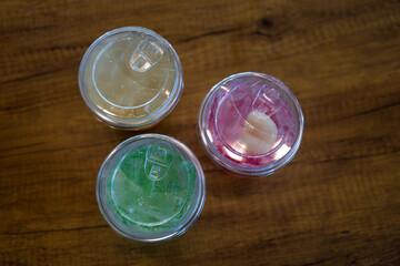 Italian soda red, green, and yellow in a plastic cup. Top view