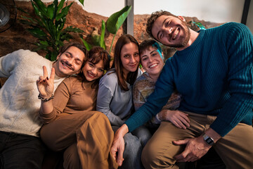 Cheerful millennials bonding in a candid group portrait indoors