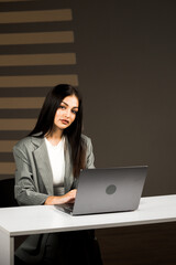 Young Businesswoman Focused on Her Laptop in a Modern Office Environment During Daytime, Embodying Professionalism and Success in Remote Work