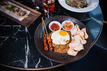 Indonesian fried rice with egg, satay and cracker