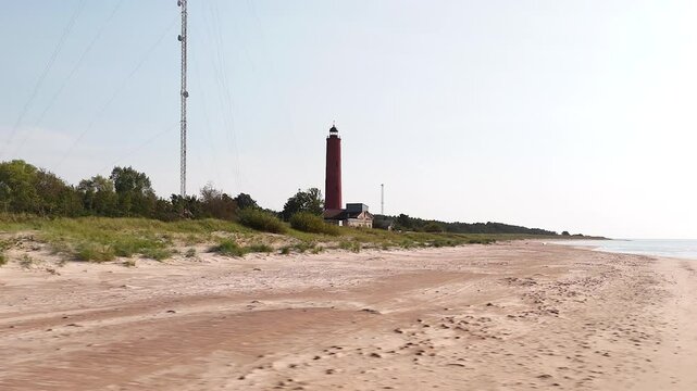 Akmenraga Baka Lighthouse On The Latvian Coast of the Baltic Sea. Aerial Drone Shot