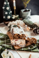 Christmas stollen decorated with a cinnamon stick on a festive table, Scandinavian style, Scandinavian Christmas, stollen with powdered sugar, raisins, candied fruits