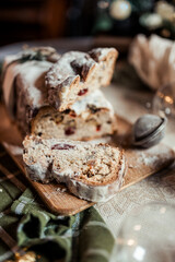 Christmas stollen decorated with a cinnamon stick on a festive table, Scandinavian style, Scandinavian Christmas, stollen with powdered sugar, raisins, candied fruits