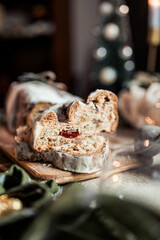 Christmas stollen decorated with a cinnamon stick on a festive table, Scandinavian style, Scandinavian Christmas, stollen with powdered sugar, raisins, candied fruits