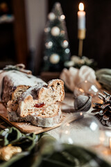 Christmas stollen decorated with a cinnamon stick on a festive table, Scandinavian style, Scandinavian Christmas, stollen with powdered sugar, raisins, candied fruits