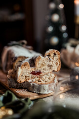 Christmas stollen decorated with a cinnamon stick on a festive table, Scandinavian style, Scandinavian Christmas, stollen with powdered sugar, raisins, candied fruits