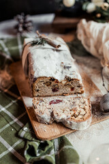 Christmas stollen decorated with a cinnamon stick on a festive table, Scandinavian style, Scandinavian Christmas, stollen with powdered sugar, raisins, candied fruits