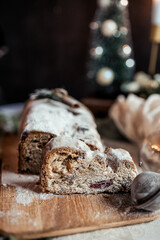 Christmas stollen decorated with a cinnamon stick on a festive table, Scandinavian style, Scandinavian Christmas, stollen with powdered sugar, raisins, candied fruits