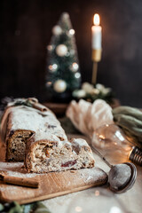Christmas stollen decorated with a cinnamon stick on a festive table, Scandinavian style, Scandinavian Christmas, stollen with powdered sugar, raisins, candied fruits