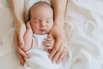 Baby sleeping in arms of his loving mother. Baby care.