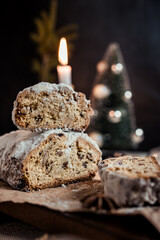 Christmas stollen decorated with a cinnamon stick on a festive table, Scandinavian style, Scandinavian Christmas, stollen with powdered sugar, raisins, candied fruits