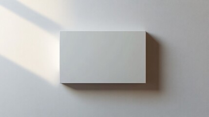 Simple blank white box on a white wall, ideal for creative design, branding, or minimalist presentations in a neutral setting.