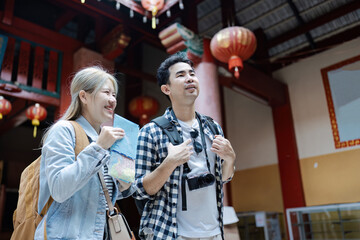 Joyful Travelers Exploring a Vibrant Asian Market with Maps and Cameras, Immersed in Culture and Adventure
