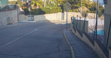 Street with a fence on the side and a gate