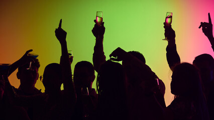 Neon swirls and shimmering drinks highlight vibrant crowd dancing and celebrating life together in electrifying atmosphere. Concept of party, youth, carefree, celebration. ad