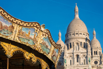 Romantic Montmartre: Sacré-Cœur and a vintage carousel under a clear blue sky