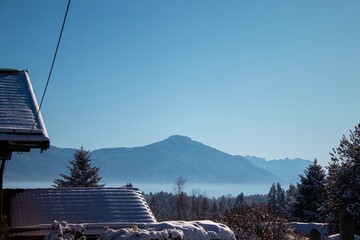 Winter Landscape Featuring Snow-Covered Mountains and Trees Under Clear Blue Sky in a Tranquil...