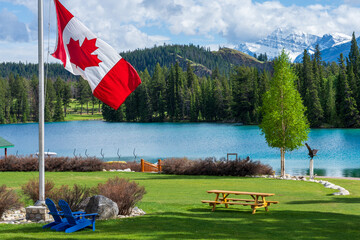 Canadian flag and mountains and trees. Jasper National Park summer landscape. Lac Beauvert Trail...