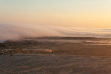 Tower lookout with beautiful sunrise at Lighthouse of Rubjerg Knude. Denmark north coast with wonderfully illuminated sea fog.
