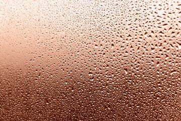 Mocha and Mousse, brown background of drops on glass in glow of sunset. Perfect background for your design and inspiration. Selective focus, defocus. Demonstrating color of 2025 year