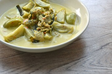 spicy boiled slice beef meat with eggplant in coconut milk green curry soup on plate