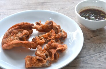 crispy fried pork innards with flour on plate dipping with spicy tamarind sauce 