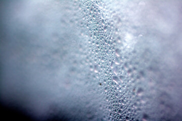 Close Up of Condensation Floating Liquid Water Bubbles and Drips on Glass from Rain