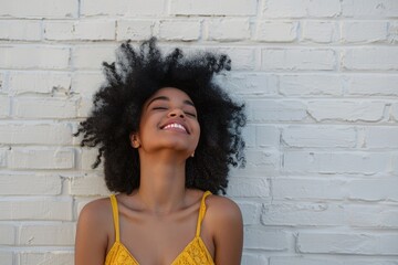 Stylish African American woman in trendy yellow sundress laughs.