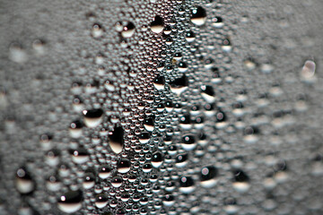 Close Up of Condensation Floating Liquid Water Bubbles and Drips on Glass from Rain