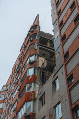 Fototapeta premium Russian missile hits residential building in Dnipro, Ukraine. Aftermath of enemy attack on city. Destroyed residential multi-story building. Close-up. War. Aftermath of explosion.