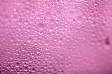 Close Up of Condensation Floating Liquid Water Bubbles and Drips on Glass from Rain