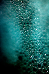 Close Up of Condensation Floating Liquid Water Bubbles and Drips on Glass from Rain