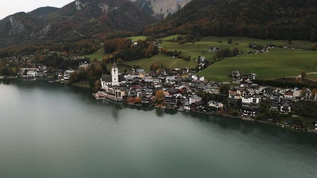 moving aerial shot of Wolfgang am Wolfgangsee from far away on a cloudy day