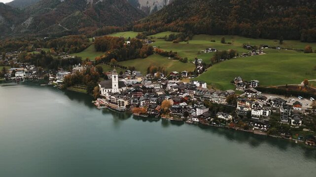 moving aerial drone shot of Wolfgang am Wolfgangsee from far away on a rainy day