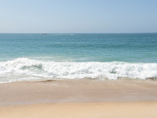 Beach with waves in Nazaré, Portugal. Vacation, surfing, giant waves, tourist destination, summer, surfing and surfer.