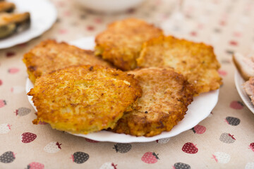 Potato pancakes with sour cream on white plate