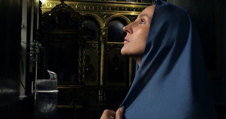 Catholic woman prays in elegant church. Folded hands and contemplative expression reflect deep faith and connection to divine presence in sacred atmosphere. Concept of Christianity and faith in god